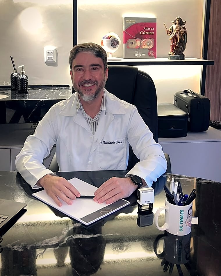 Dr. Thales Lamartine, oftalmologista, sentado à mesa do seu consultório em Belém